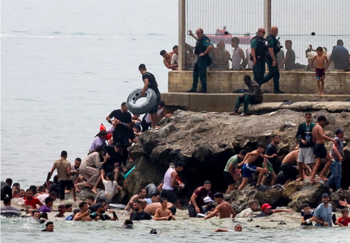 Thousands of migrants cross into Spanish enclave of Ceuta as border controls overwhelmed